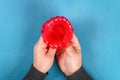 Diy Easter egg basket made of red plastic cup decorated with artificial flowers on blue background Royalty Free Stock Photo