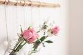 DIY Festive decoration of living room. Roses in jars are suspended from white wall, selective focus