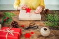 DIY Gift Wrapping. Unrecognisable woman wrapping beautiful nordic style christmas gifts. Cropped shot.