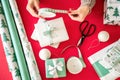 DIY Gift Wrapping. Unrecognisable woman wrapping beautiful nordic style christmas gifts. Hands close up.