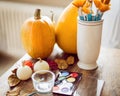 DIY Halloween concept. Art and craft, decorating Halloween pumpkins. Color pallete, paintbrush and pumpkins on a table.