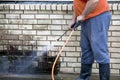 Man powerwashing mold of wall - DIY