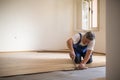 Senior landlord lying parquet floor board/laminate flooring in a rental appartement