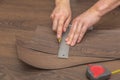 DIY vinyl flooring. Easy installation and cutting with a knife, Master cuts vinyl plank before installation, brown Royalty Free Stock Photo