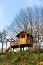 DIY wooden children playhouse with swing and slide on hillside Royalty Free Stock Photo