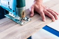 DIY worker cutting wooden panel with jig saw Royalty Free Stock Photo