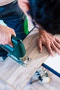 DIY worker cutting wooden panel with jig saw Royalty Free Stock Photo