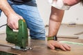 DIY worker cutting wooden panel with jig saw Royalty Free Stock Photo