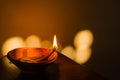 diya or earthen oil lamp lit with flame during diwali celebration in india. deepabali or kali puja is celebrated across india as a