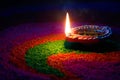 Diya lamp on top of colorful rangoli