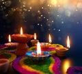 Diya lamps lit on colorful rangoli