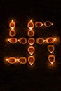 Diwali oil lamp or diya arranged to form swastik symbol