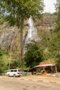 Sunny day in the Tropical waterfall falls from the mountain cliff to the jungle,