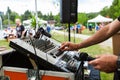 DJ is adjusting the levels on his mixing board during a community event