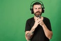 Dj with beard wears headphones, copy space. Man holds microphone Royalty Free Stock Photo