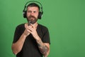 Dj with beard wears headphones, copy space. Man holds microphone Royalty Free Stock Photo