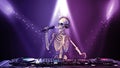 DJ Bones, human skeleton with microphone playing music on turntables, skeleton with disc jockey audio equipment, front view