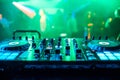 DJ booth at night club party for music mixing with green blurred background