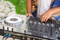 DJ hands creating and mixing music on DJ console mixer in a concert party outdoors Royalty Free Stock Photo