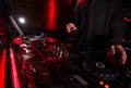 DJ hands on equipment deck and mixer at party. Cut shot of disk jockey in black hoody mixing music in night club. Night life Royalty Free Stock Photo