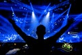 DJ hands up at night club party under blue light with crowd of people Royalty Free Stock Photo