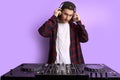 Dj man in white headphones behind dj console, makes song with dj controller. Royalty Free Stock Photo