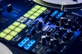 DJ mixing deck and turntables at night with controls for mixing music for a party or disco