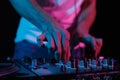 DJ mixing music on party. Club disc jockey adjusting volume on sound mixer in close up, focus on hands