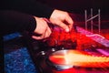 DJ mixing music on professional music equipment with colorful red effects