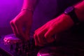 Dj mixing on turntables with color light effects. Soft focus on hand. Close-up.