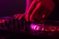 Dj mixing on turntables with color light effects. Soft focus on hand. Close-up.
