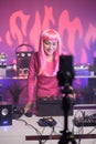 Dj with pink hair recording music session with smartphone camera while playing song at mixer console Royalty Free Stock Photo