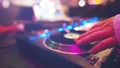 dj playing on controller at nightclub, man mixing music at party with turntable emulation