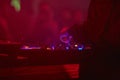 Dj playing on music equipment, party. colorful red lights. festival, rave