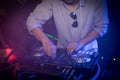 DJ playing turntable music on night club