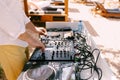 DJ plays music on the beach. Dj mixing beach party in summer vacation outdoor. Disc jockey hands playing music for