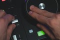 DJ plays music. sound mixer controller with knobs and sliders. hands on the mixing deck with turntables at dark with illuminated