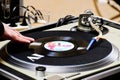 dj scratching on 45 speed small black vinyl on retro style turntable. closeup view with male hand Royalty Free Stock Photo