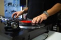 Hip hop disc jockey scratches vinyl records on turn table in music store