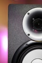 DJ studio monitor speaker with disco lighting background