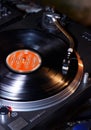 Dj turntables needle cartridge on black vinyl record with music. Close up, focus on turntable and audio disc record Royalty Free Stock Photo