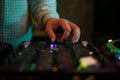 Hip hop dj plays music with sound mixer. Hand of disc jockey on cross fader knob. Professional disk jokey mixing musical tracks on Royalty Free Stock Photo