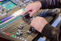 DJ using switch controller mixer to control an audio mixing console live during a streaming event Royalty Free Stock Photo