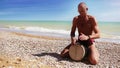 Djembe Drum Player beat rythm on the lonely beach