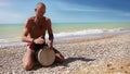 Djembe traditional Drum Player beat rythm on the lonely beach