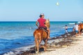 Djerba, Tunisia. July 19, 2016. A rider on a horse rides along a sandy beach Royalty Free Stock Photo