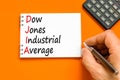 DJIA Dow Jones industrial average symbol. Concept words DJIA Dow Jones industrial average on white note on beautiful orange