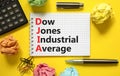 DJIA Dow Jones industrial average symbol. Concept words DJIA Dow Jones industrial average on white note on beautiful yellow