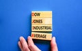 DJIA Dow Jones industrial average symbol. Concept words DJIA Dow Jones industrial average on wooden block on beautiful blue