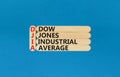 DJIA Dow Jones industrial average symbol. Concept words DJIA Dow Jones industrial average on wooden stick on beautiful blue